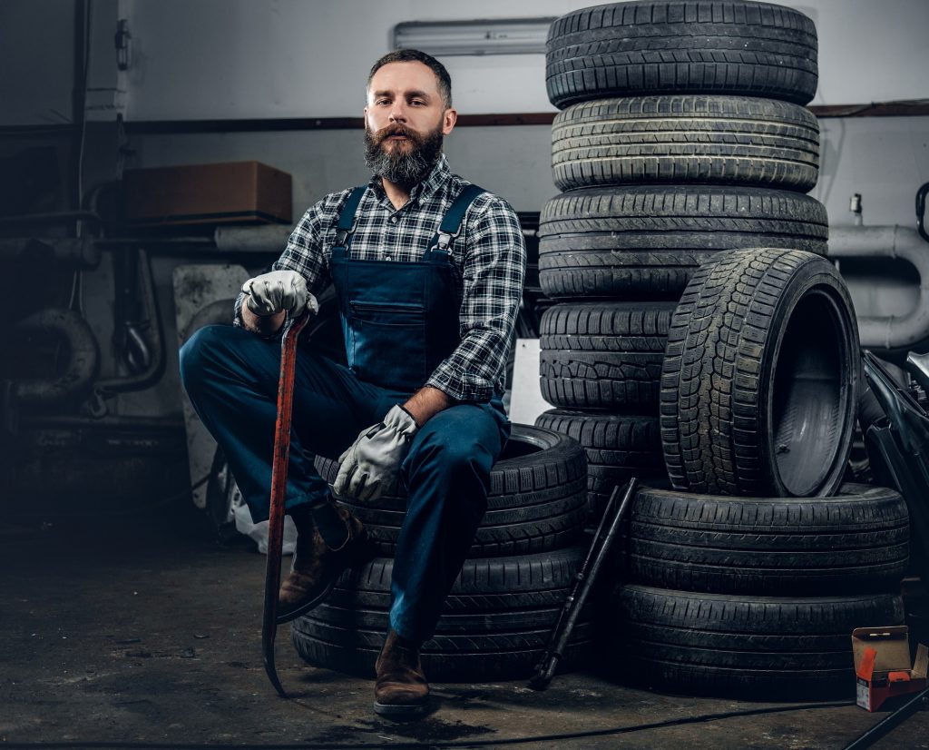 A man sits on a tire.